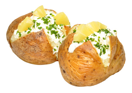 Two cottage cheese and pineapple filled baked potatoes isolated on a white backgroundの写真素材