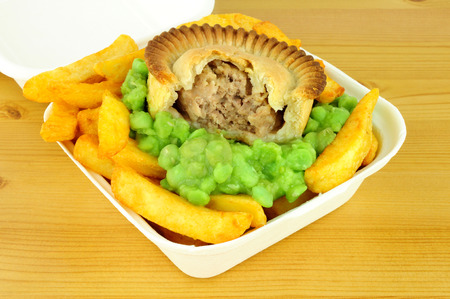 Meat pie and chips with mushy peas in a take away boxの写真素材