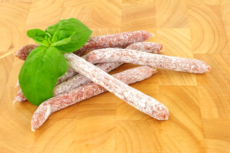 Mini salami pork stick snacks on a wood backgroundの写真素材