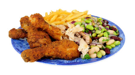 Southern fried chicken drumsticks meal with three bean salad and French fries isolated on a white backgroundの写真素材