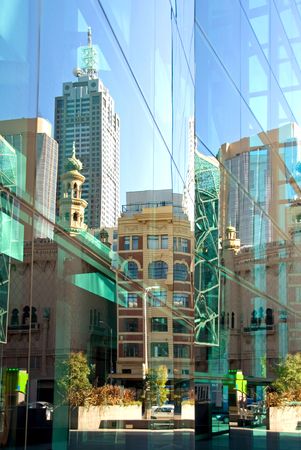 A street scene, reflected in the glass facade of a nearby inner-city office building, Melbourne, Australiaの写真素材