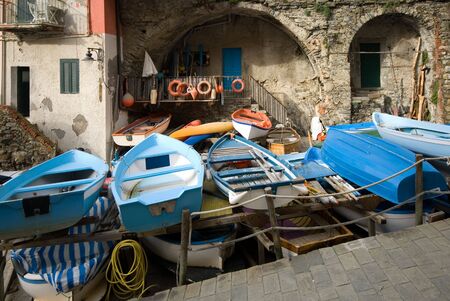Small fishing boats stored on racks, in the quaint fishing village of Riomaggiore, Cinque Terre, Italyの写真素材