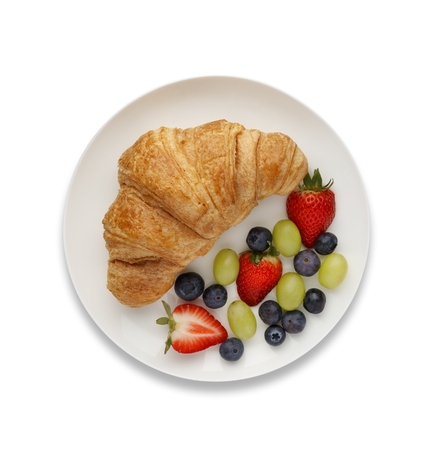 Continental breakfast of a croissant and fruit, shot from above, on white with a drop shadow.の写真素材