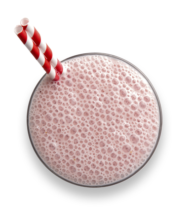 Glass of strawberry  Milkshake with frothy bubbles and straws, shot from above with drop shadowの写真素材