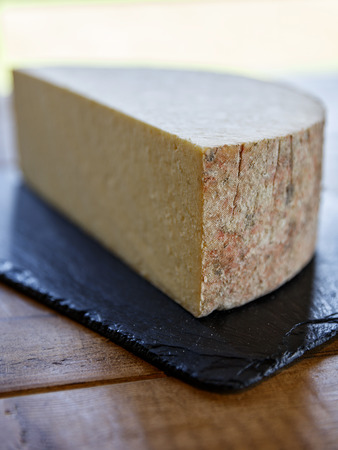 Detail focus of the rind edge of a  half round of cheeseの写真素材