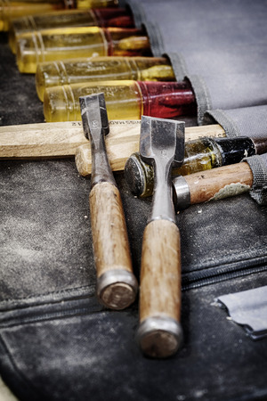 A grungy image of well used woodworking chisels side by side  in a chisel pouchの写真素材