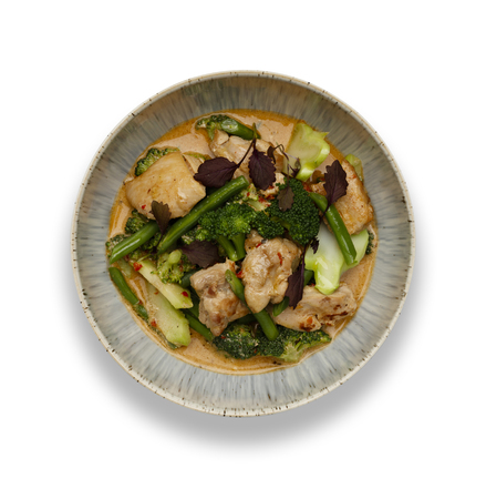 A bowl of succulent Thai Red Chicken Curry isolated on a white background with a drop shadow.の写真素材