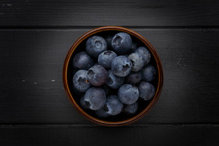 blueberries in a bowl on dark grey wooden backgroundの写真素材