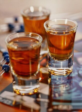 3 shot glasses full of amber whisky with a shallow depth of field.の写真素材