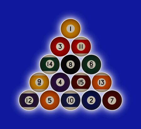 Pool balls numbered 1-15 in a triangle formation on a blue background with a hallow glow behindの写真素材