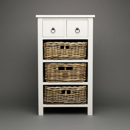 3 wicker baskets, with a white cabinet and draws, on a dark grey background.の写真素材