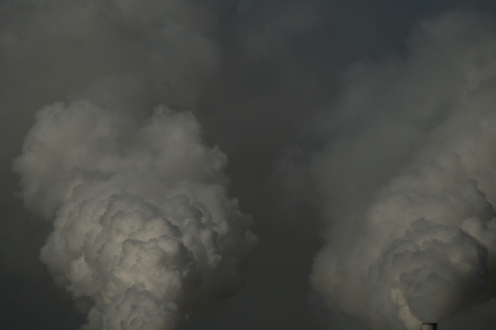 Smoke exhaust plume from a factory on blue gray skyの写真素材