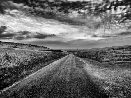 small country lane in yorkshire england with dramatic cloudsの写真素材