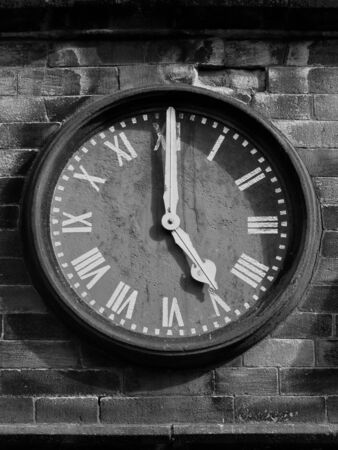 old clock face on stone wall with roman numerals