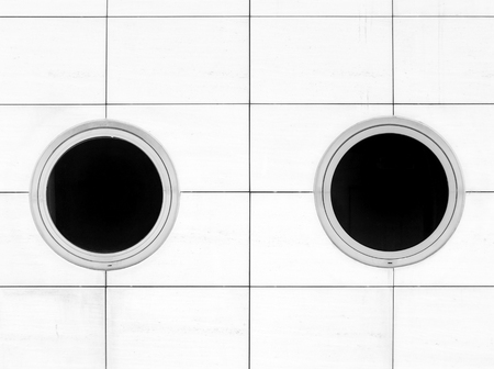 two round windows on a white wallの写真素材