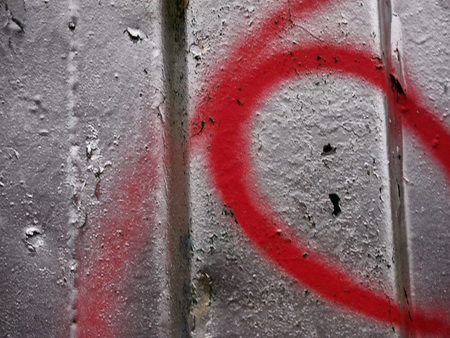 peeling silver paint on a rusting metal surface with random red paintの写真素材