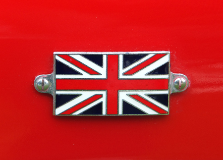Union Jack metal badge detail on a vintage red sports car