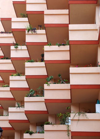 pink balconies on modern apartment building with house plantsの写真素材