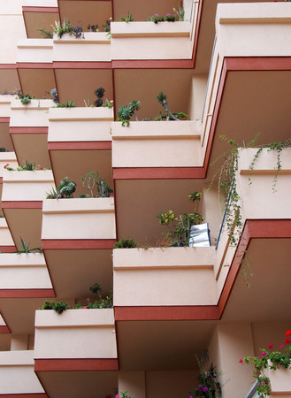 pink balconies on modern apartment building with house plantsの写真素材