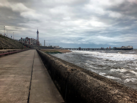 blackpool promenade with the tower and pier in the distance on a stormy winter dayの写真素材