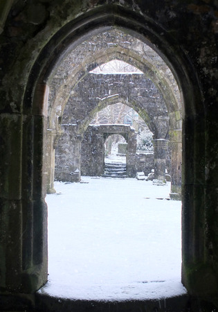 snow falling through a ruined okd church door in heptonstall in west yorkshireの写真素材