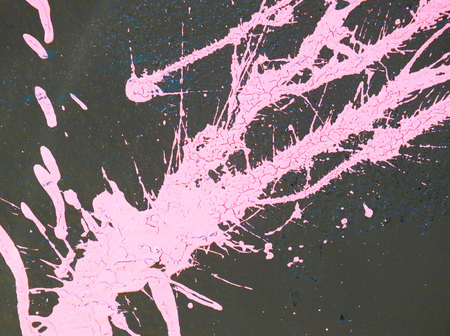 pink paint splashes and drips on a grey wallの写真素材