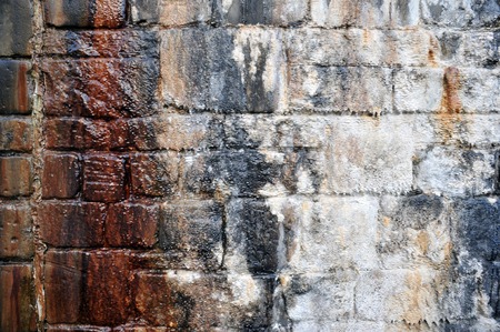 old damp streaked stone wall with white and brown stained coloursの写真素材