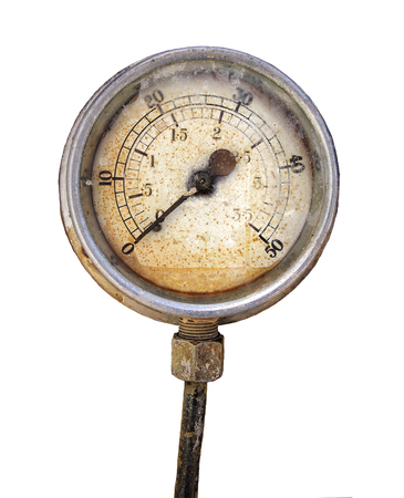 Old rusty round industrial pressure gauge with numbers round the dial mounted on a metal surface of a large abandoned diesel powered generatorの写真素材