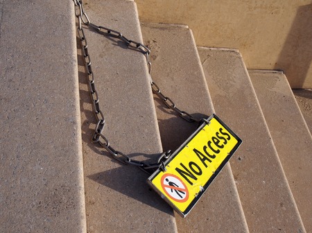 yellow metal no access sign on a chain on concrete steps with no pedestrian symbolの写真素材