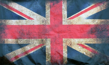a full frame image of an old stained dirty union jack british flag with dark crumpled edges