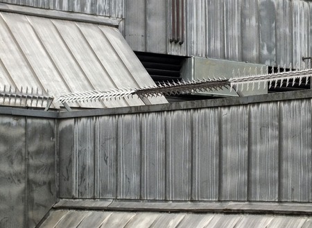 anti climb security rollers with barbed spikes on the walls and roof of a high security building...