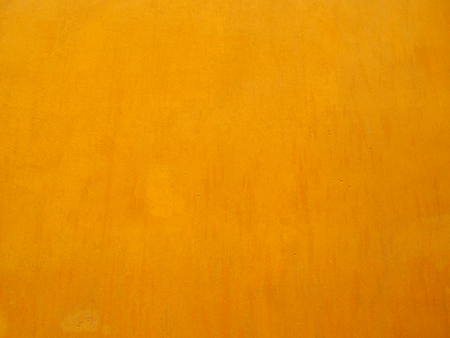 a rich warm golden yellow painted wall background with brush marks and weathered antique effectの写真素材