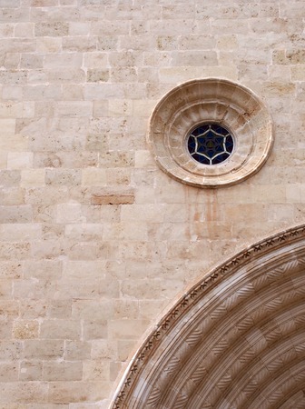 architectural medieval stone wall background with an ornate round window and section of a large carved curved achの写真素材