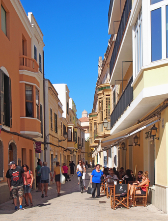 Ciutadella, Menorca / Spain - October 1 2018: Tourists and shoppers walking and sitting in an outdoor cafe in the street in Ciutadella Menorca town centerのeditorial素材