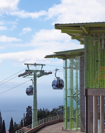 funchal, madeira, portugal - 13 march 2019: gondolas outside the overhead cable car station in monte running from funchal in madeira with blue sky and sea in the backgroundのeditorial素材