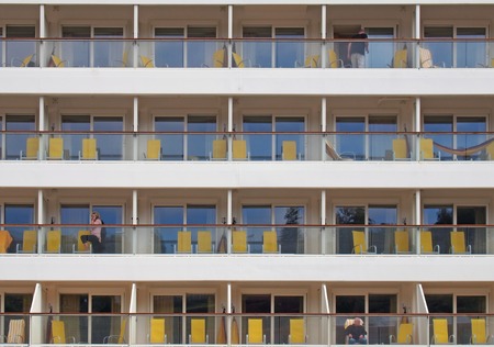 funchal, madeira, portugal - 13 march 2019: close up of a cruise ship moored in funchal harbor showing cabins with sun loungers and passengers relaxingのeditorial素材