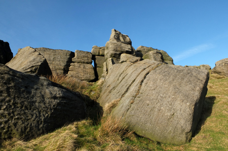 large rugged gritstone outcrop at the bridestones a large rock formation in west yorkshire near todmordenwith blue sky and surrounding countrysideの写真素材