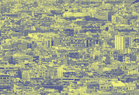 A blue and yellow duotone crowded urban cityscape  with hundreds of densely packed buildingsの写真素材