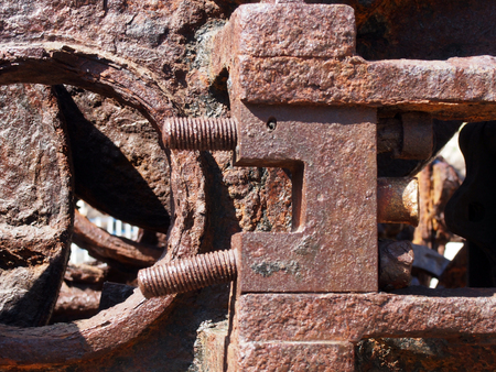 A close up of brown rusted threaded bolts and nuts on old corroded machineryの写真素材