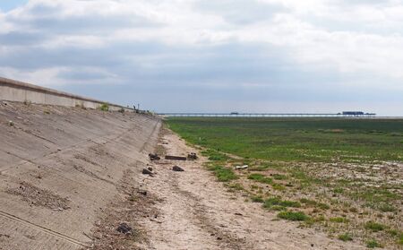 a path along the seawall in grassy coastal marshland alone the ribble and alt estuary in merseyside looking towards southport with the pier in the distanceの写真素材
