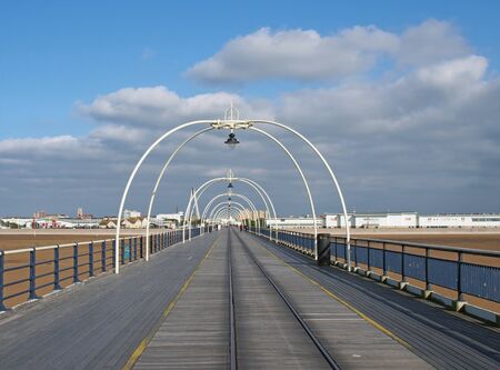 southport, merseyside, united kingdom - 28 june 2019: a panoramic view along the pier in southport merseyside with the beach at low tide on a summer day with buildings of the town and a blue skyの写真素材