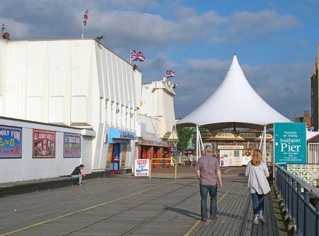 southport, merseyside, united kingdom - 28 june 2019: people walking into the entrance to southport pier in merseyside with a carousel and amusement arcadeのeditorial素材