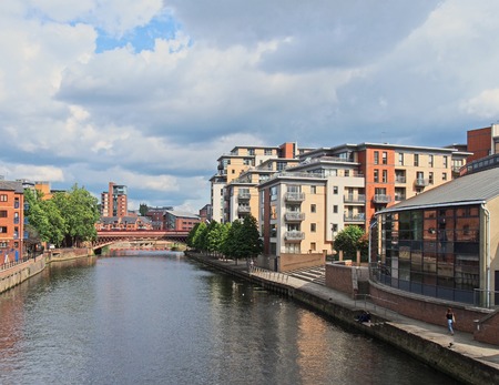 leeds, west yorkshire, united kingdom - 16 july 2019: a view of the river aire in leeds with apartment buildings around crown point bridge and people walking along the waterfrontのeditorial素材