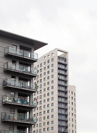 leeds, west yorkshire, united kingdom - 14 july 2019: clarence house a 218 foot tall modern apartment and retail building and adjacent apartments in the leeds dock area against a cloudy skyのeditorial素材