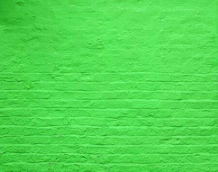 an old rough brick wall painted a vivid bright green colorの写真素材