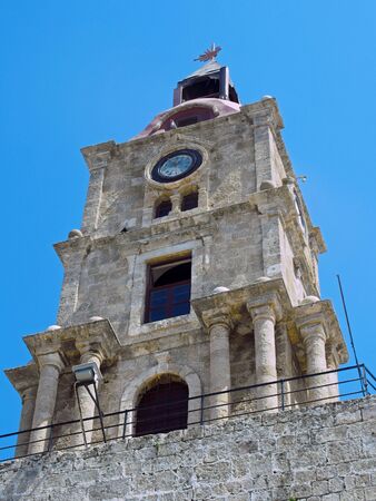 the historic roloi medieval clock tower in rhodes town against a blue sky