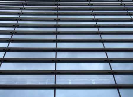 a vertical perspective view of the facade of a modern glass commercial building with steel frames...