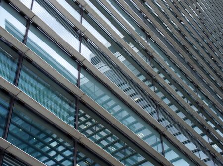 a diagonal perspective view of the facade of a modern glass commercial building with steel frames...