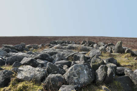 the exposed stones at the top of a cairn known as the millers grave on midgley moor in calderdale...
