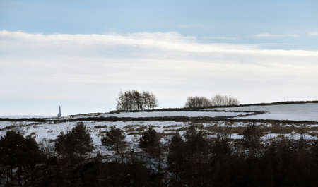 snow covered fields with stoodley pike monument and moors in the distance in calderdale west yorkshireの写真素材